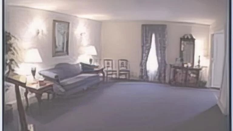 A room in a traditional style; blue couch, dark carpet, blue curtains.