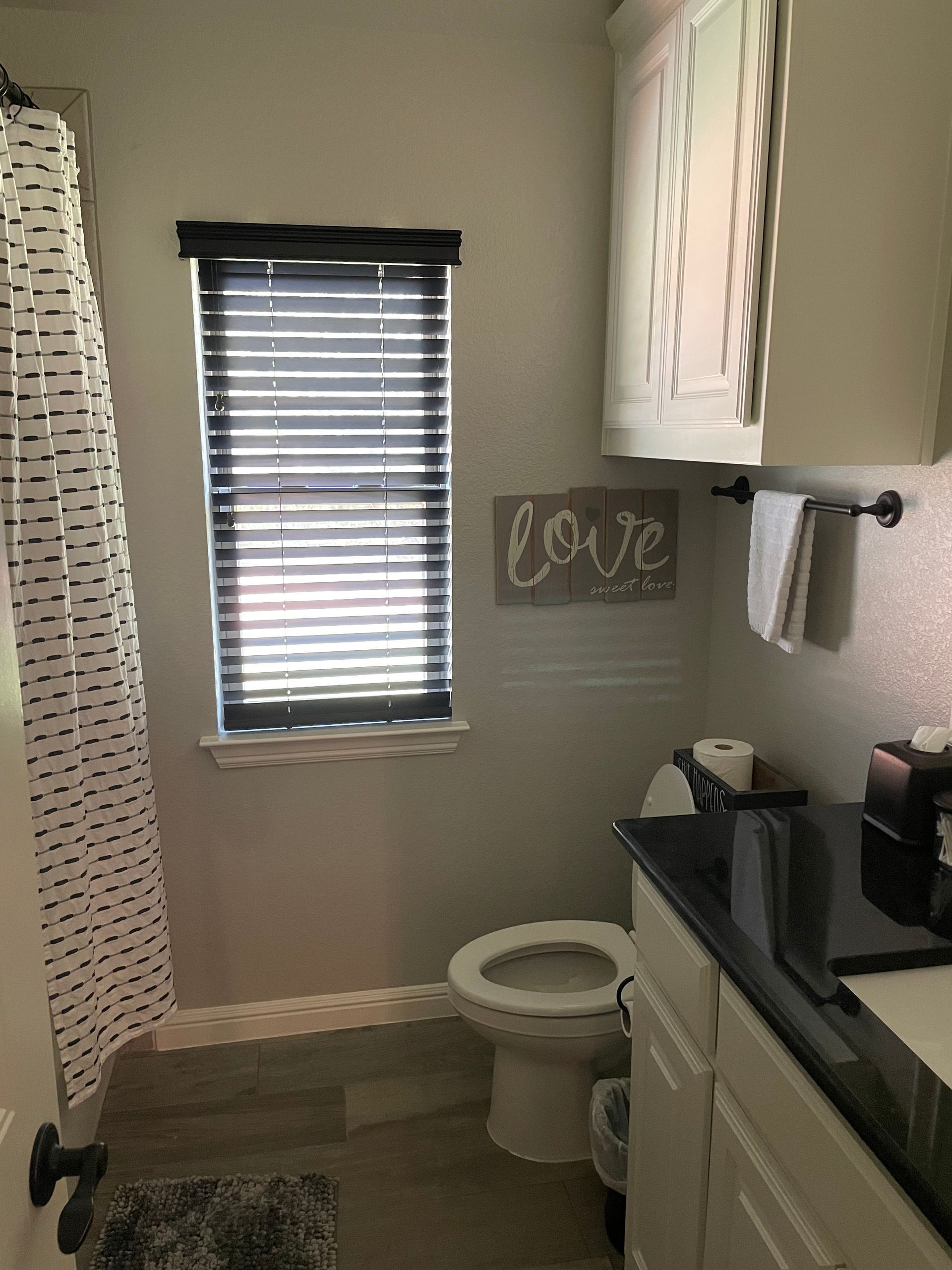 Small bathroom with a toilet, window with blinds, vanity, and a 