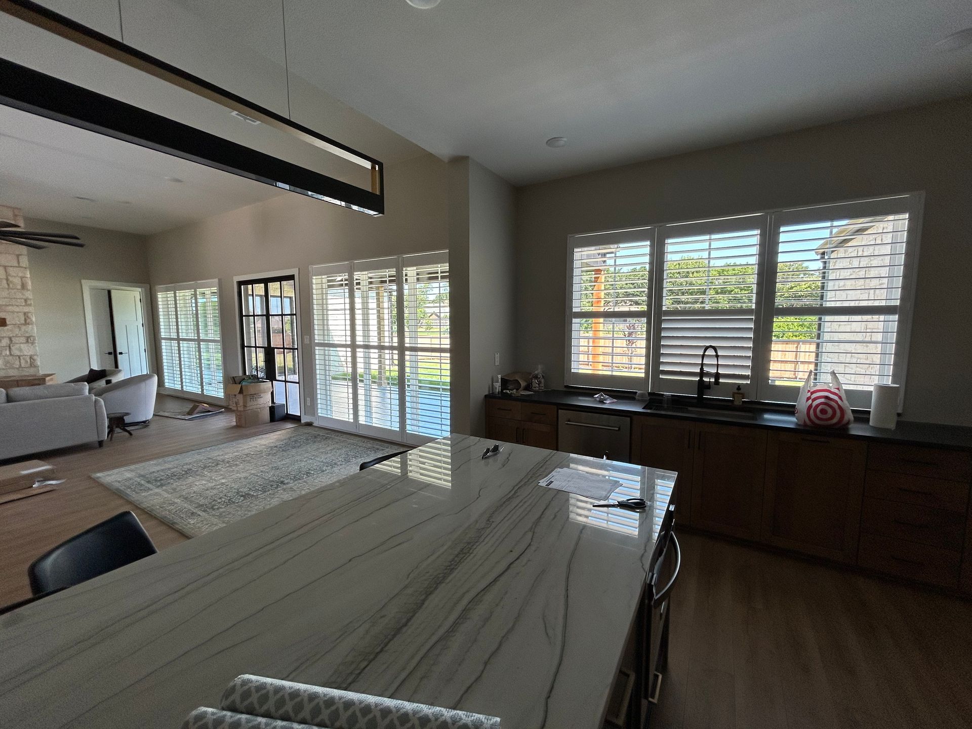Kitchen with island, windows, and cabinets. Light and airy interior with a view to the outside.