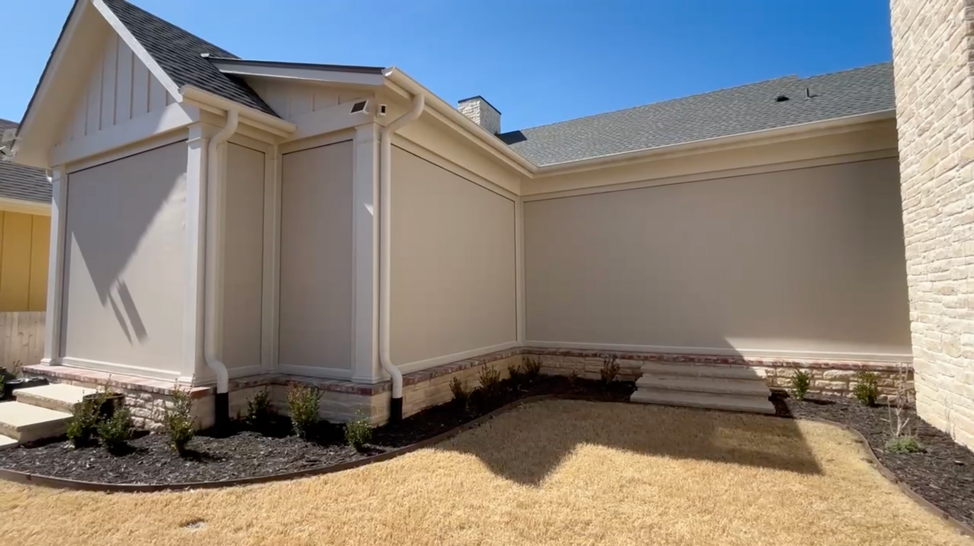 Exterior house with beige walls, cream trim, and a gray roof.