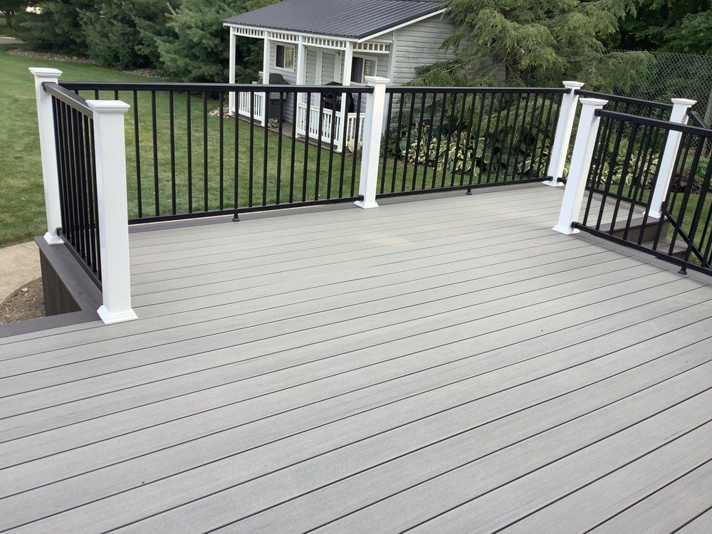 A composite deck with a black railing and white posts.