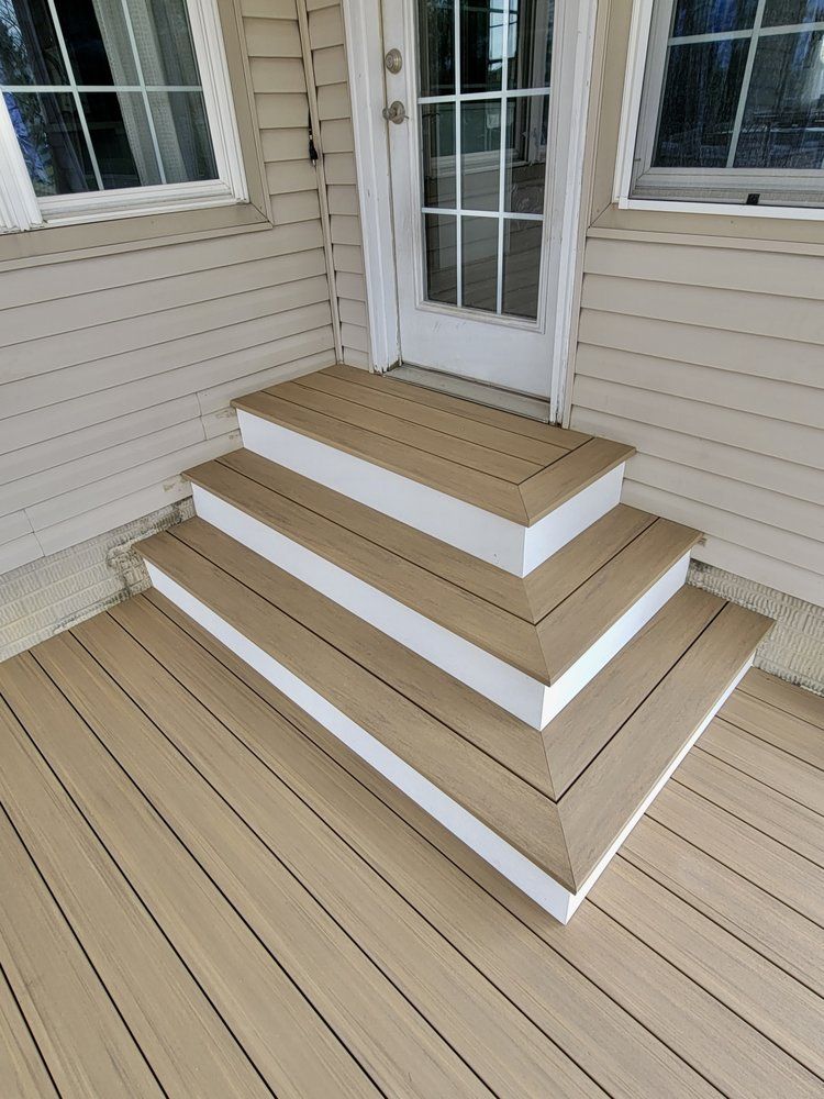 A wooden deck with stairs leading up to a door.