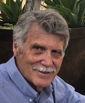 A man with glasses and a mustache is smiling for the camera.