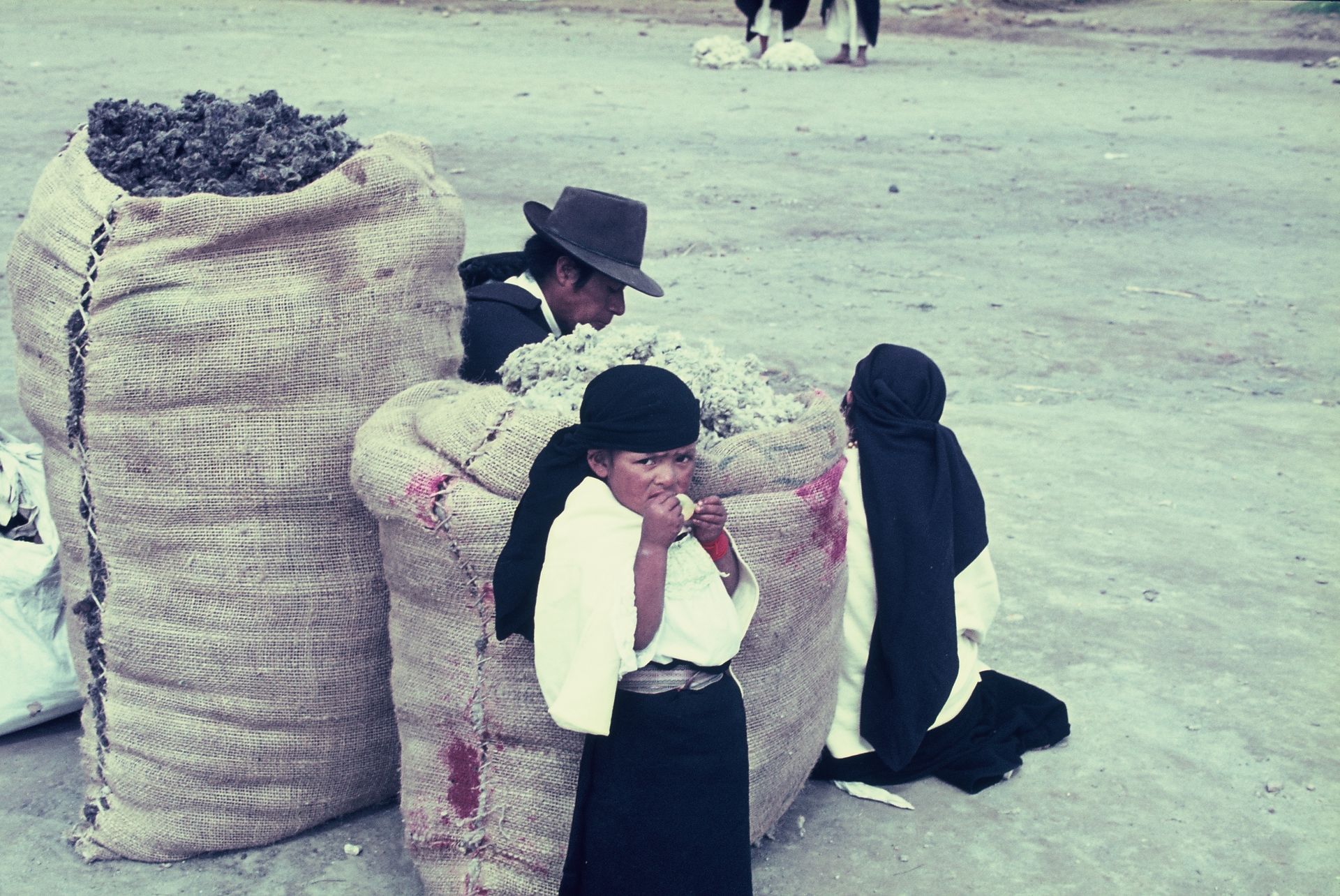 A group of people are standing around a pile of bags
