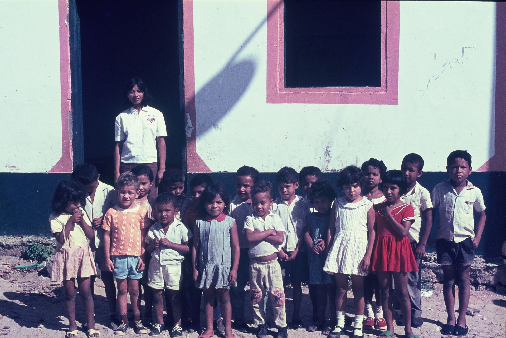 A group of children standing in front of a white building
