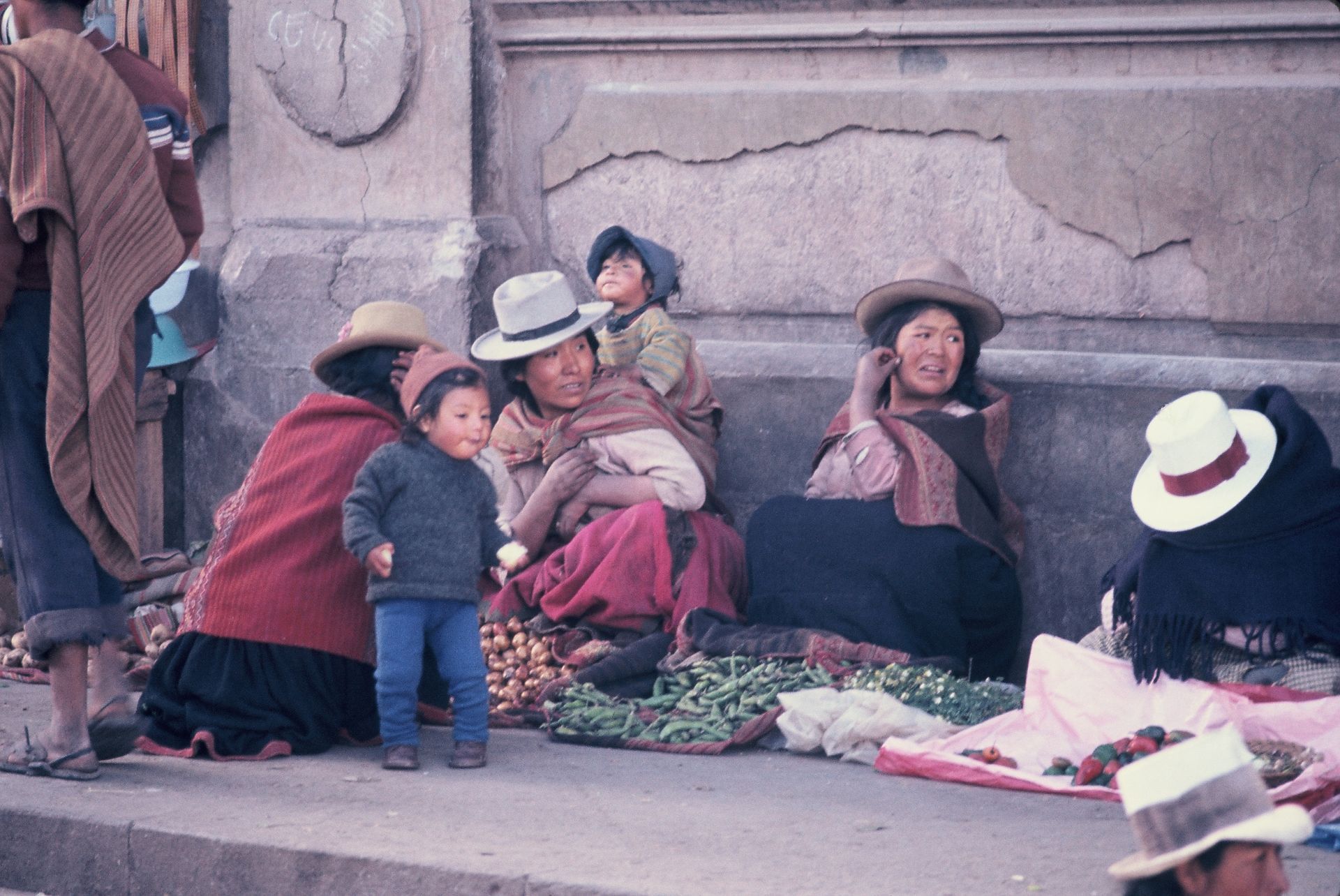 A group of people sitting on a sidewalk including a child