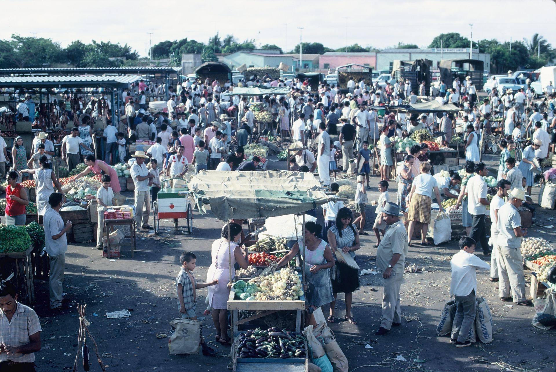 A large crowd of people are gathered at a market
