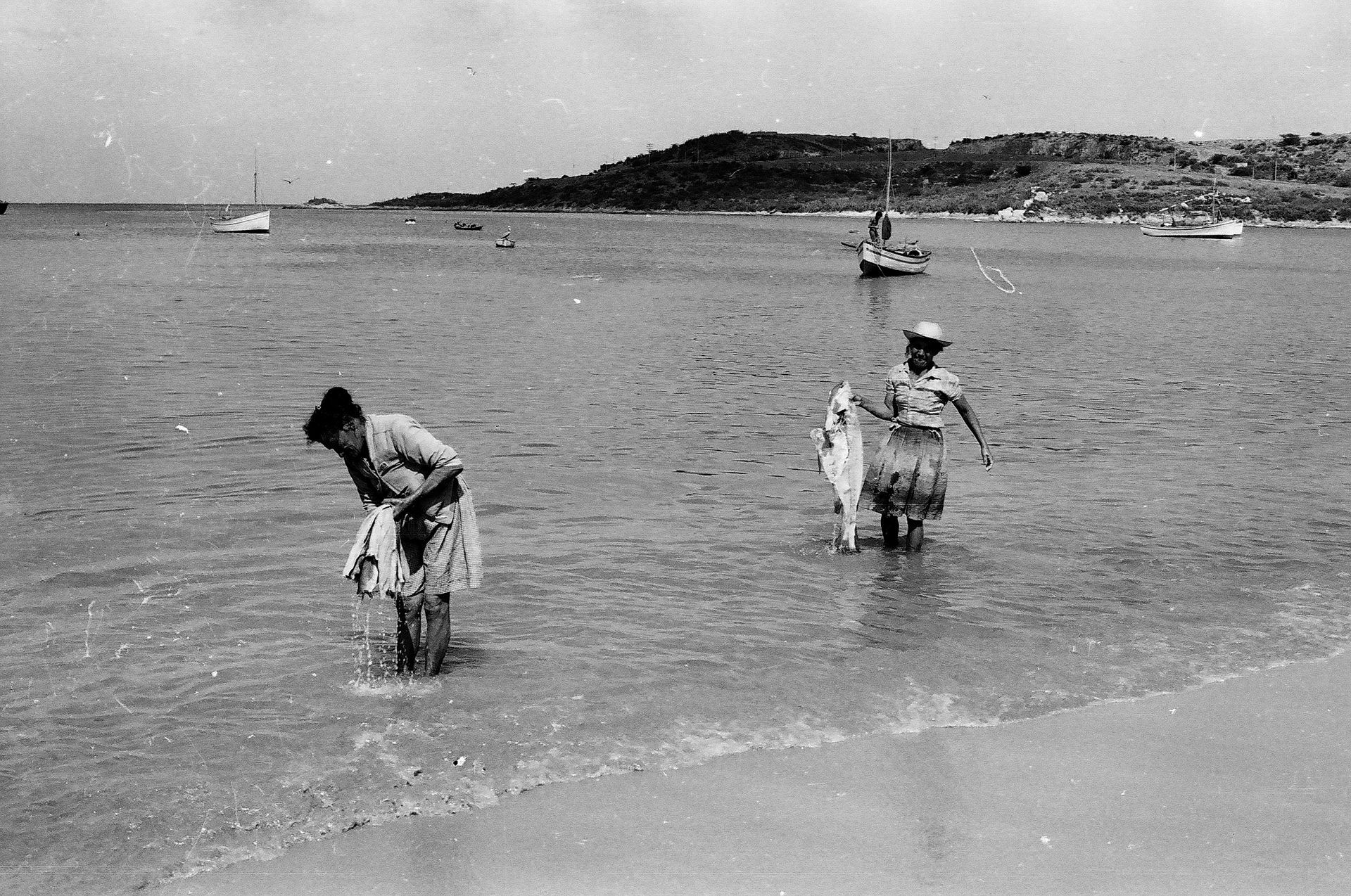 A black and white photo of two people in the water