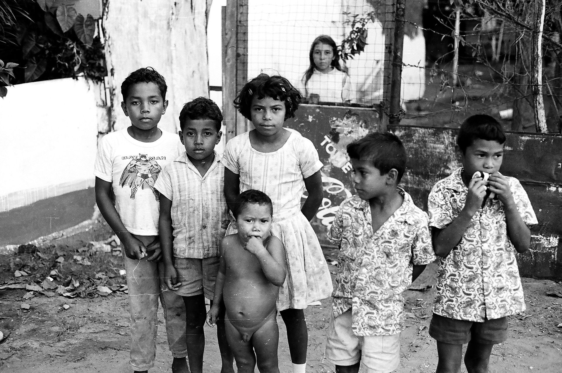 A group of children are posing for a picture in front of a building.