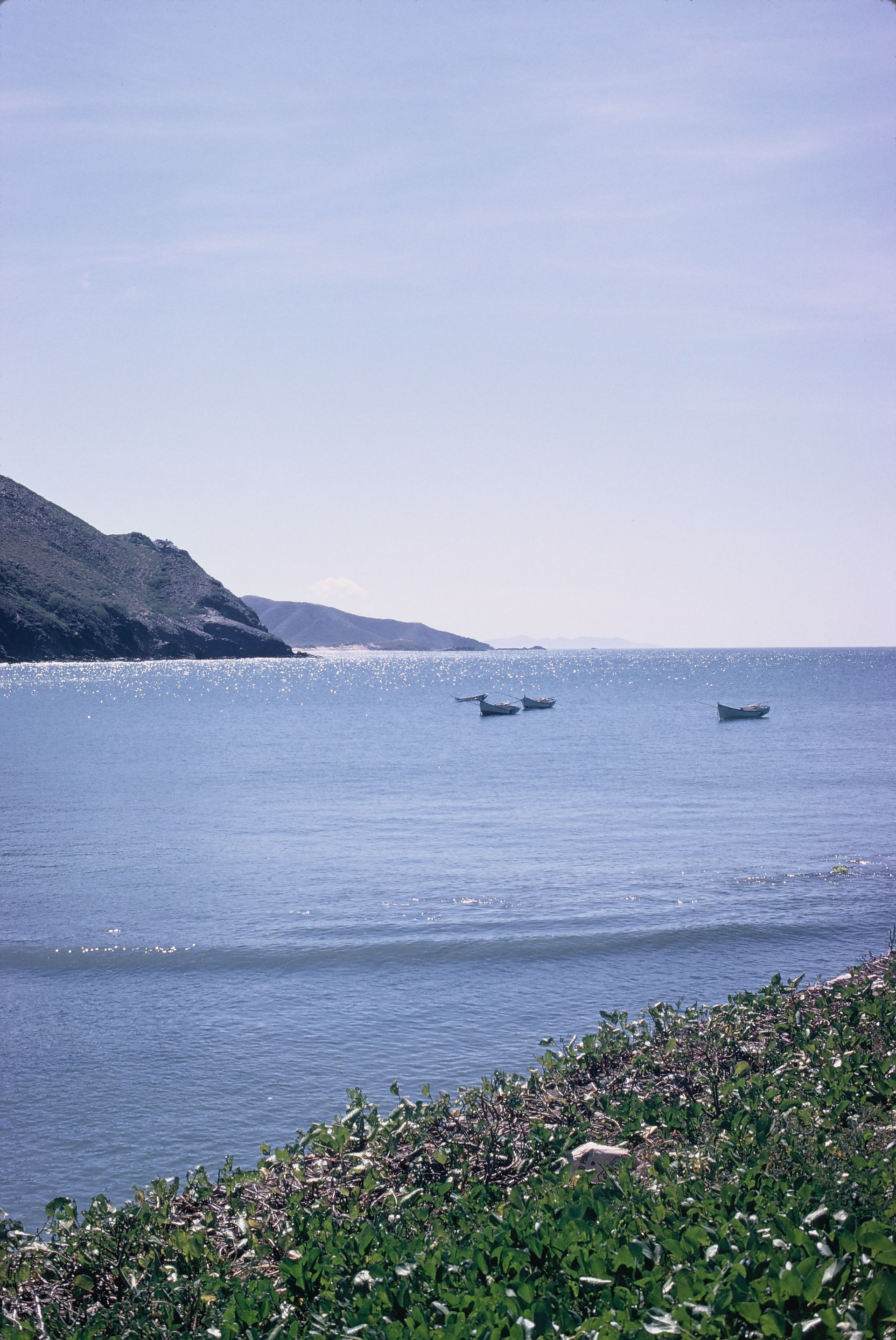A couple of boats are floating on top of a body of water.
