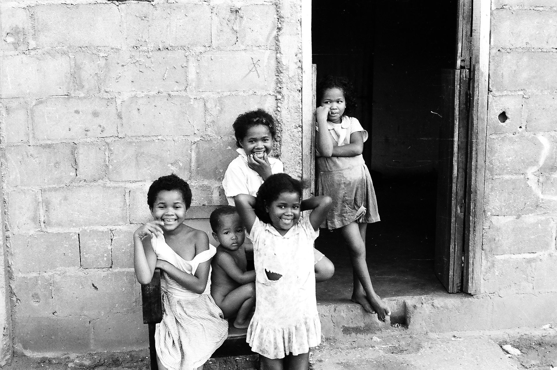 A group of children are posing for a picture in front of a building.