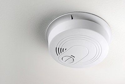 A smoke detector is mounted to the ceiling of a room.