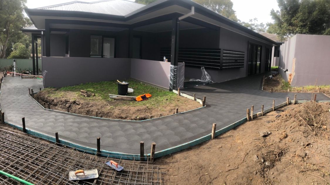 A Large House With a Concrete Walkway in Front of It — Coastal Kerb and Concrete In Buff Point, NSW