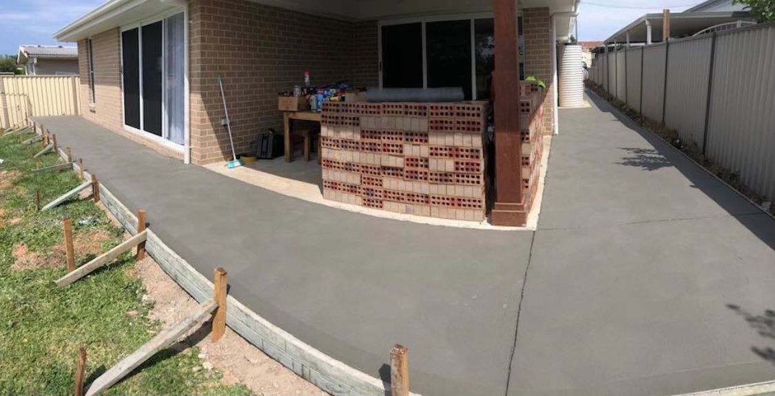 Curve Concrete Pathway With Green Trimmed Bush — Contact Our Concreters in Morisset, NSW