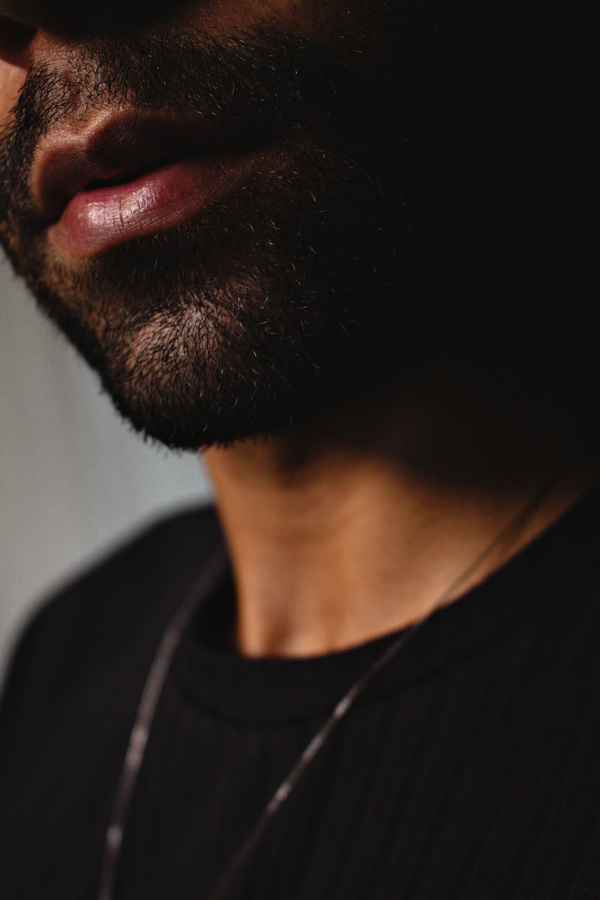 Hairdresser cutting wet, dark hair with scissors and comb.