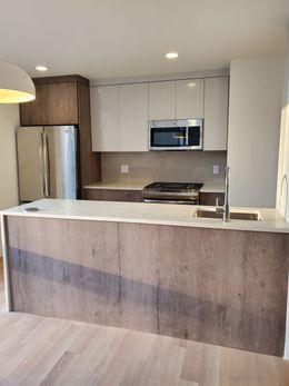A kitchen with wooden cabinets and white counter tops