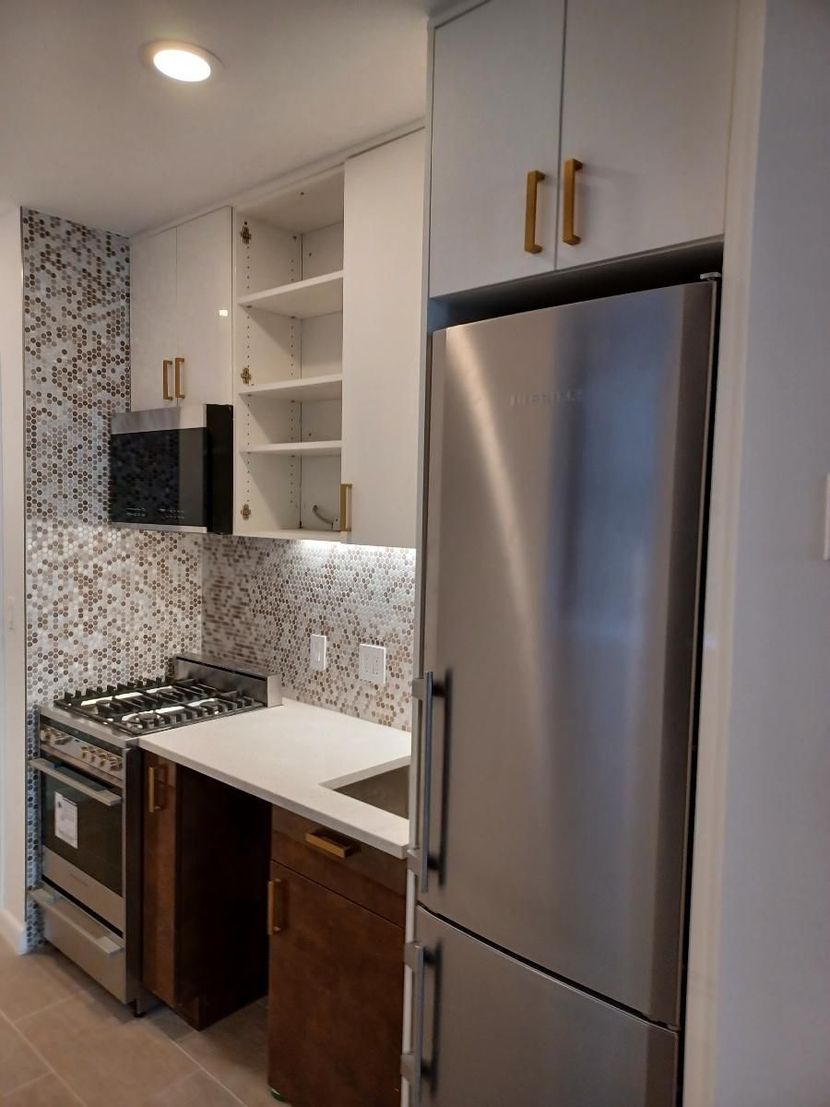A kitchen with stainless steel appliances including a refrigerator and stove
