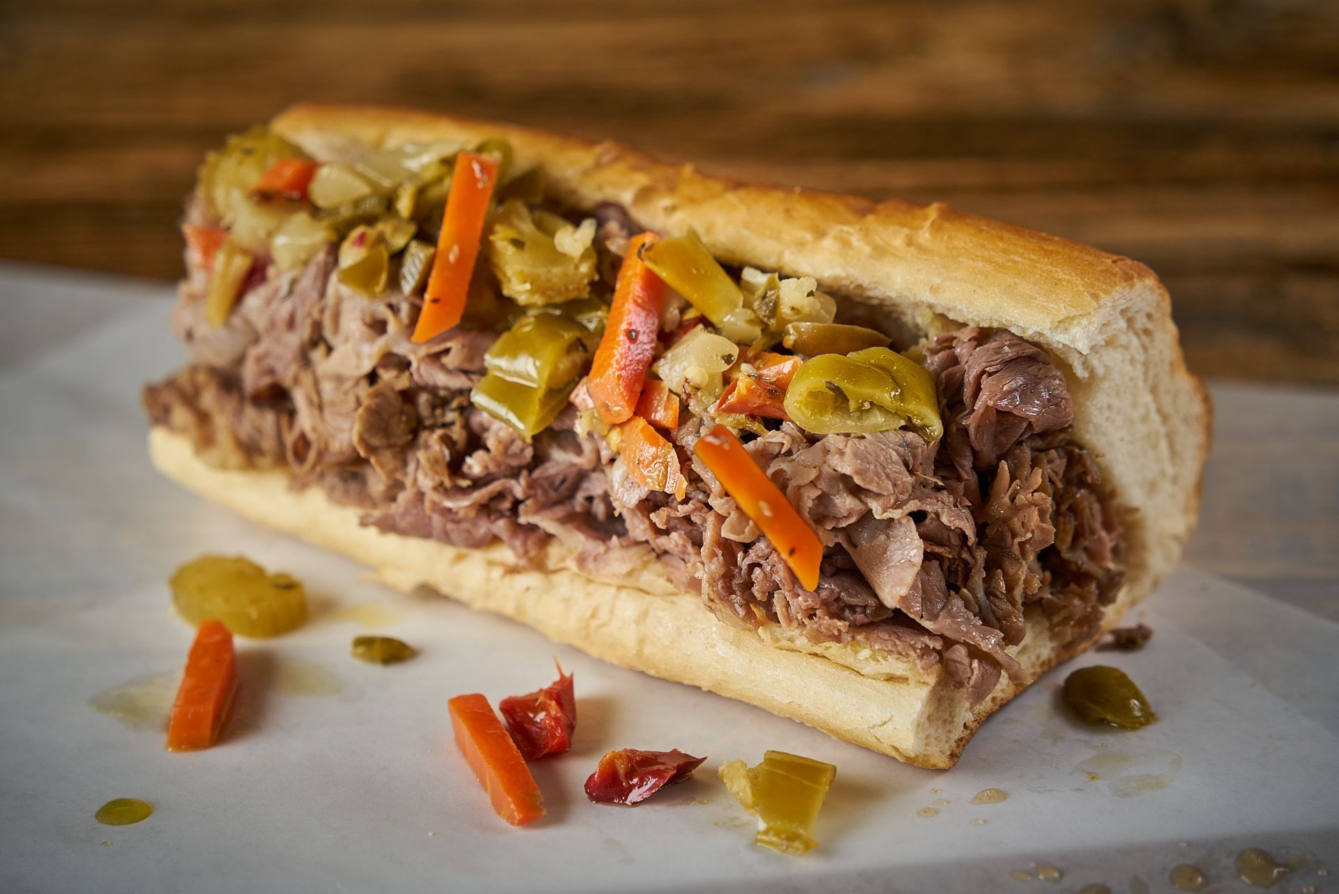 Italian beef sandwich, shredded beef on a crusty roll, topped with pickled vegetables.
