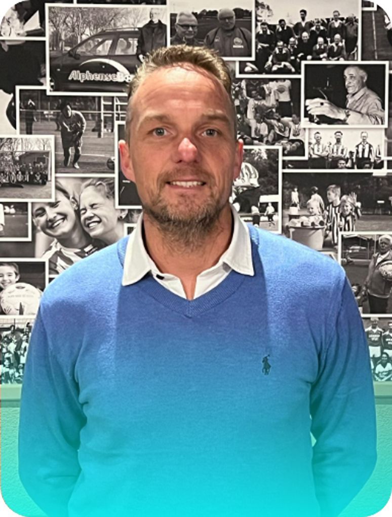 Man in blue sweater, white collar, smiles; photo collage background.