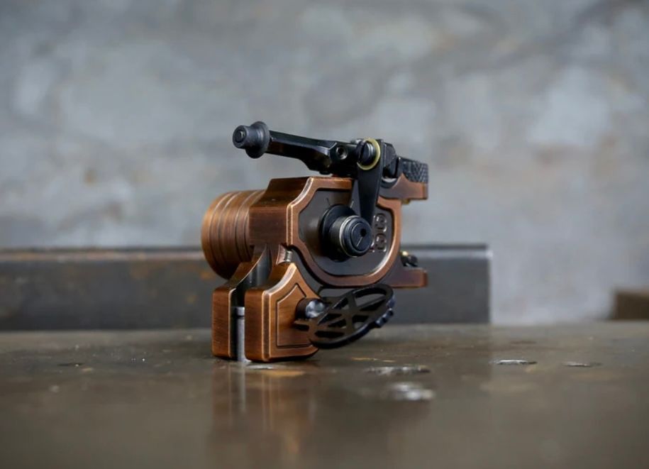 A tattoo machine is sitting on a wooden table.