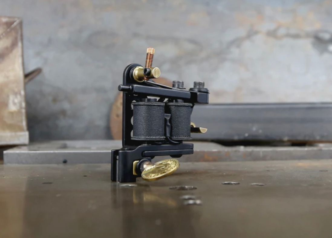 A black tattoo machine is sitting on a table.
