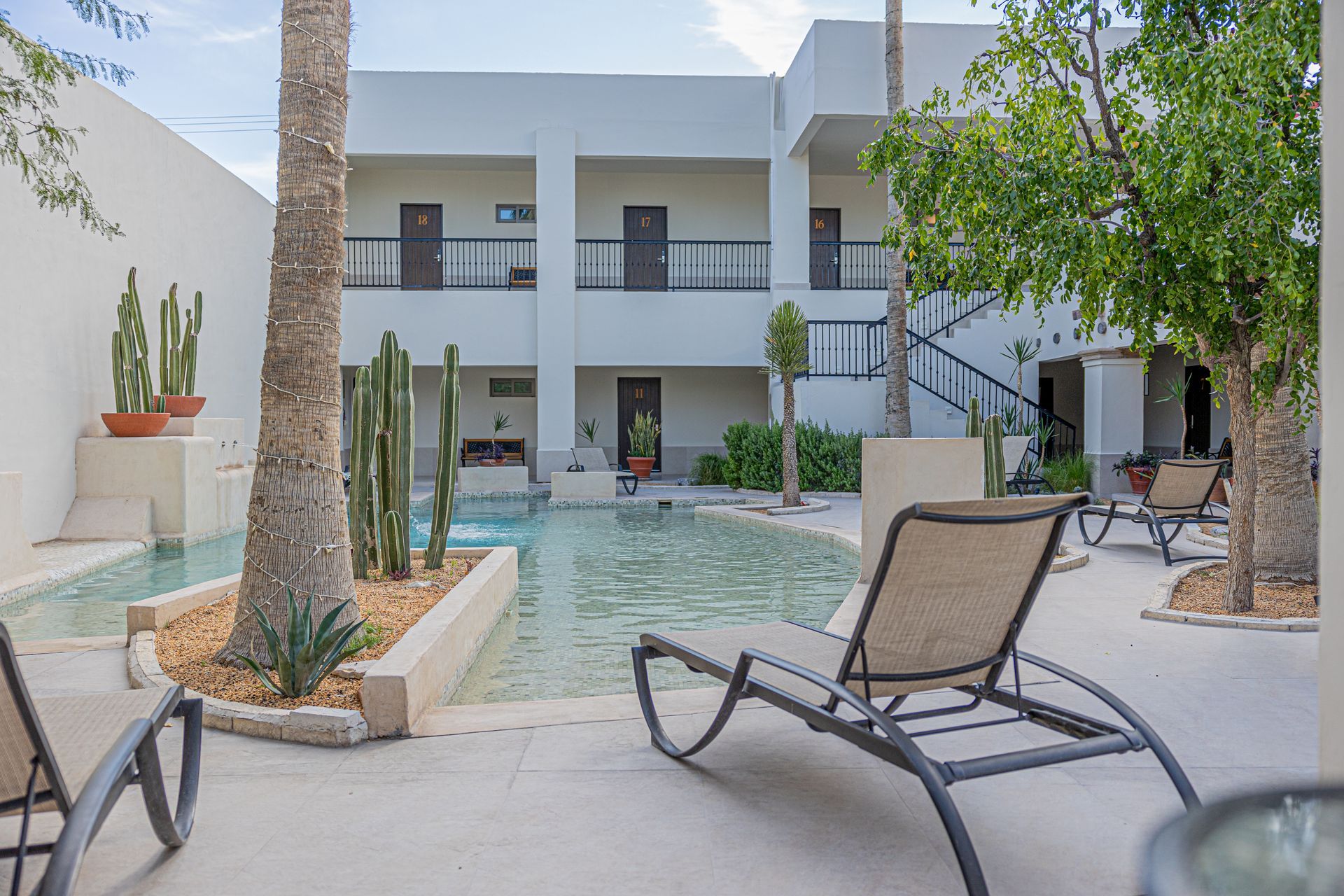 Un gran edificio blanco con una piscina delante.