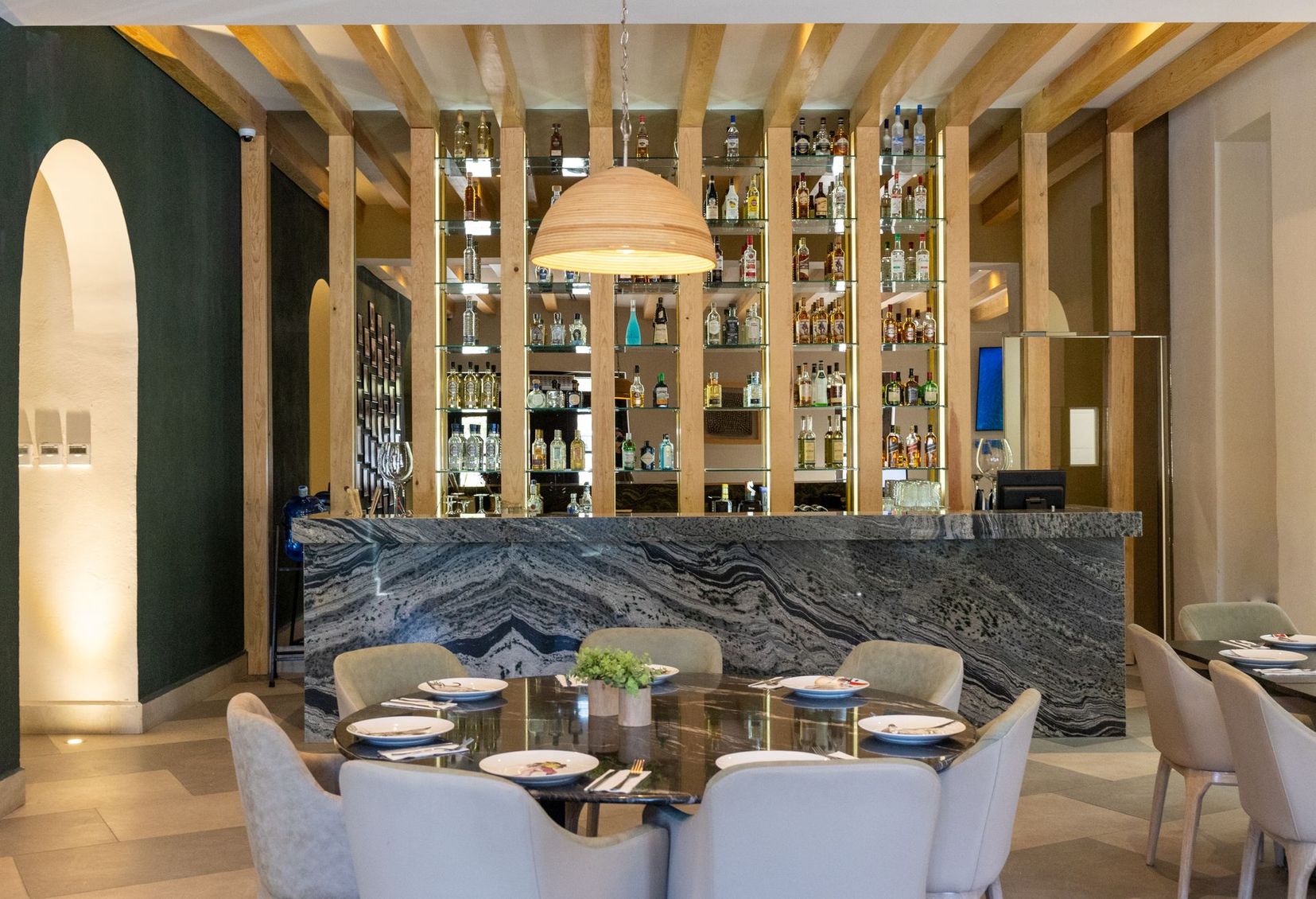 Un restaurante con mesas y sillas y un bar al fondo.