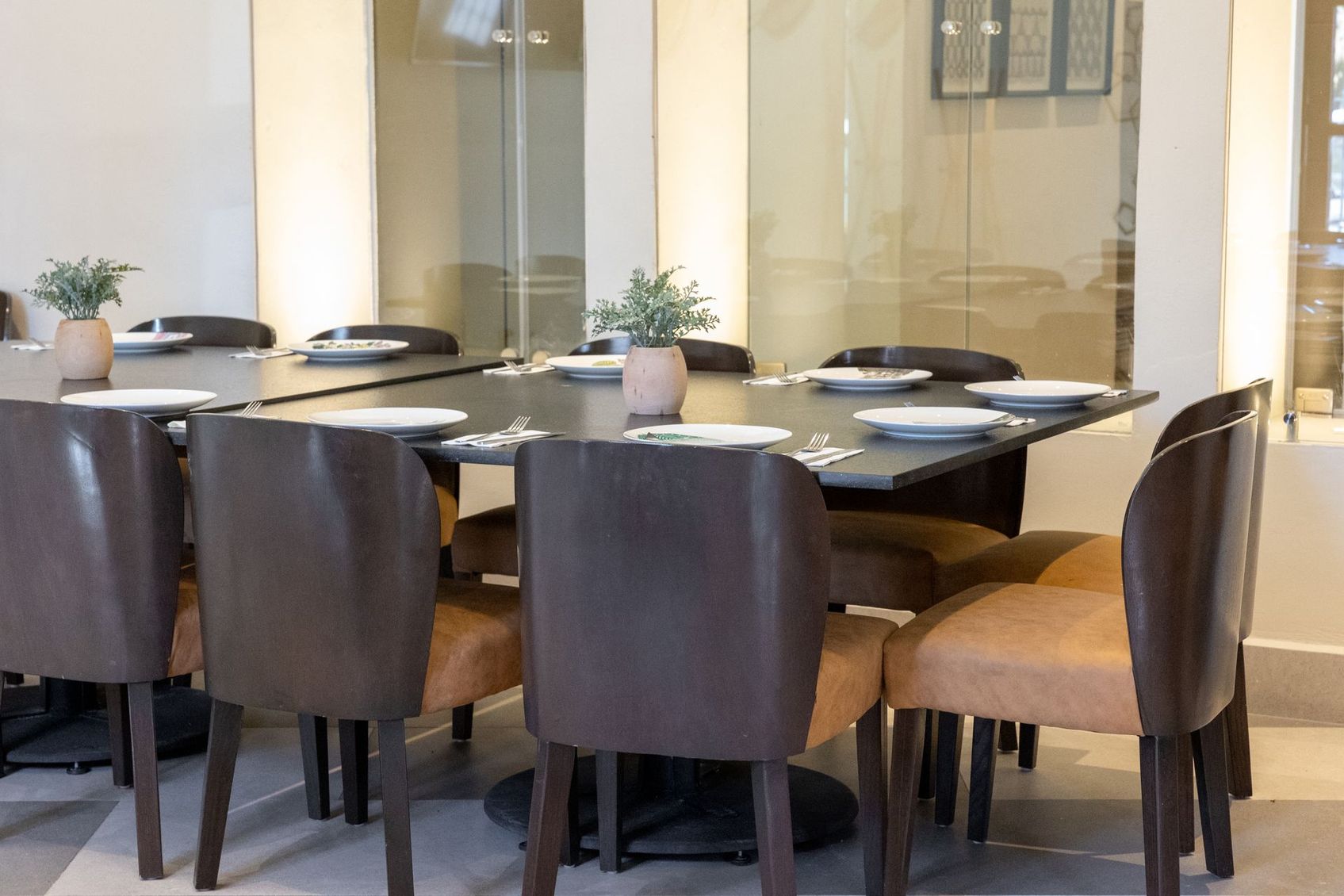 Una mesa de comedor con sillas y platos encima.