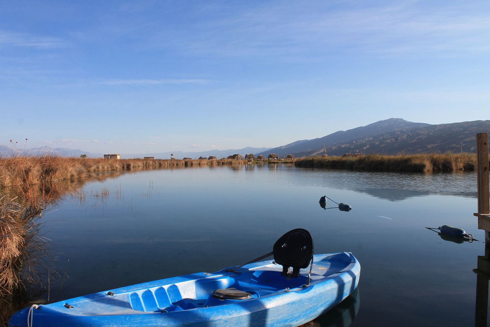 Un kayak azul está atracado en el medio de un lago.