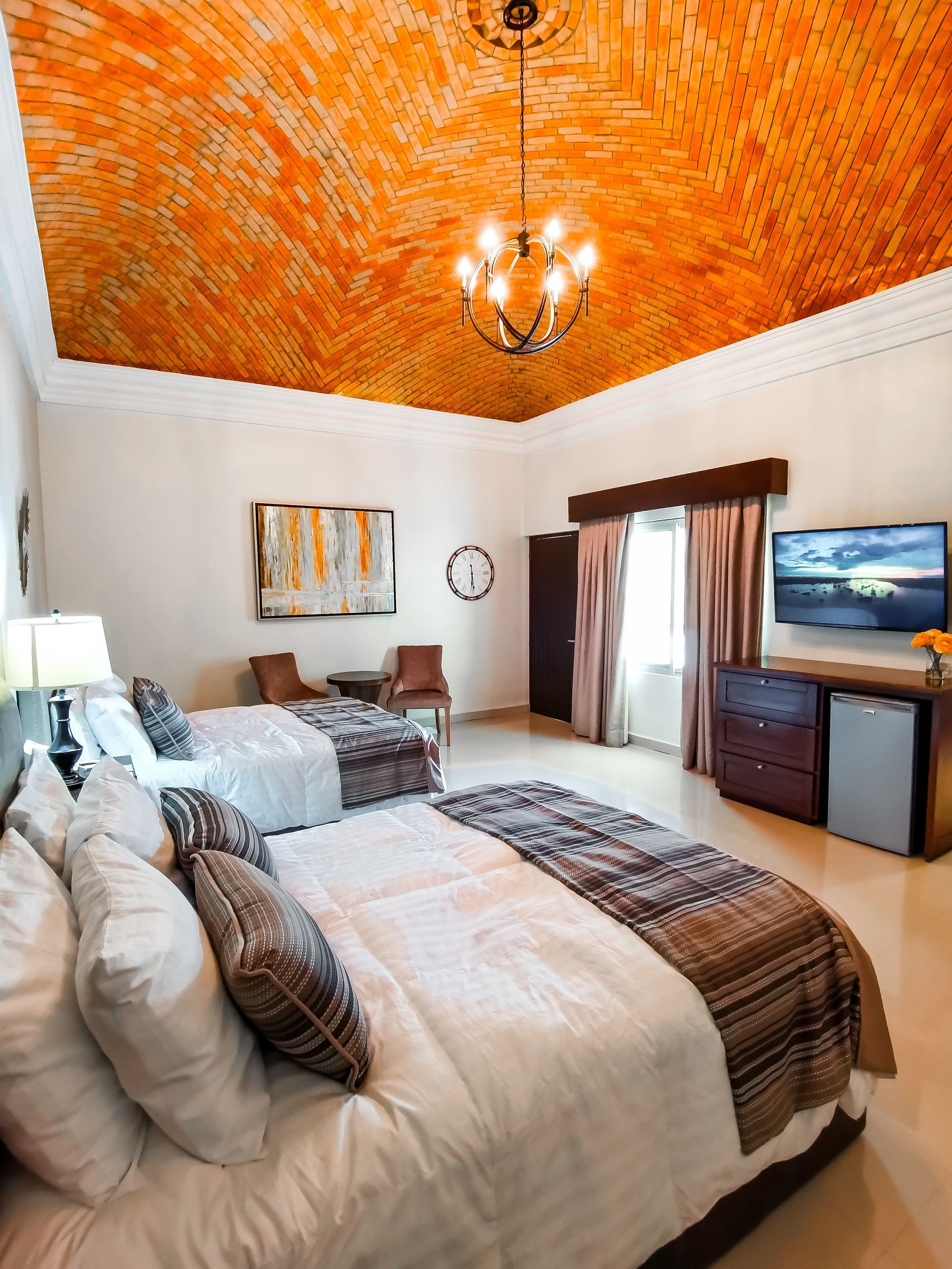 Una habitación de hotel con una cama tamaño king y un televisor de pantalla plana.