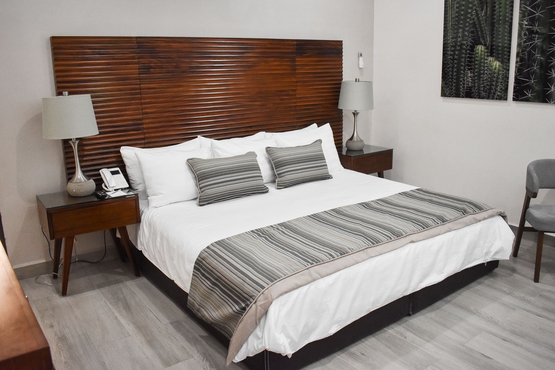 Una habitación de hotel con una cama tamaño king y dos lámparas.