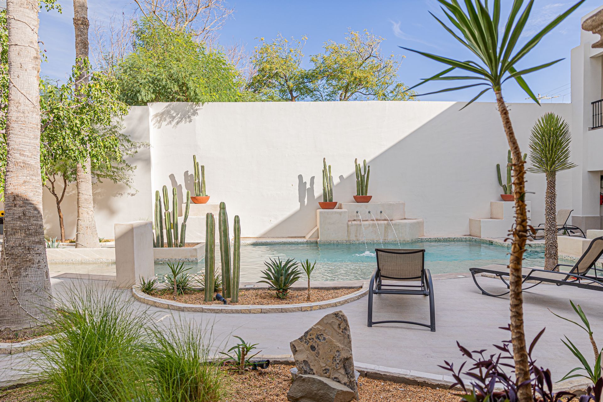 There is a large swimming pool in the backyard of a house.