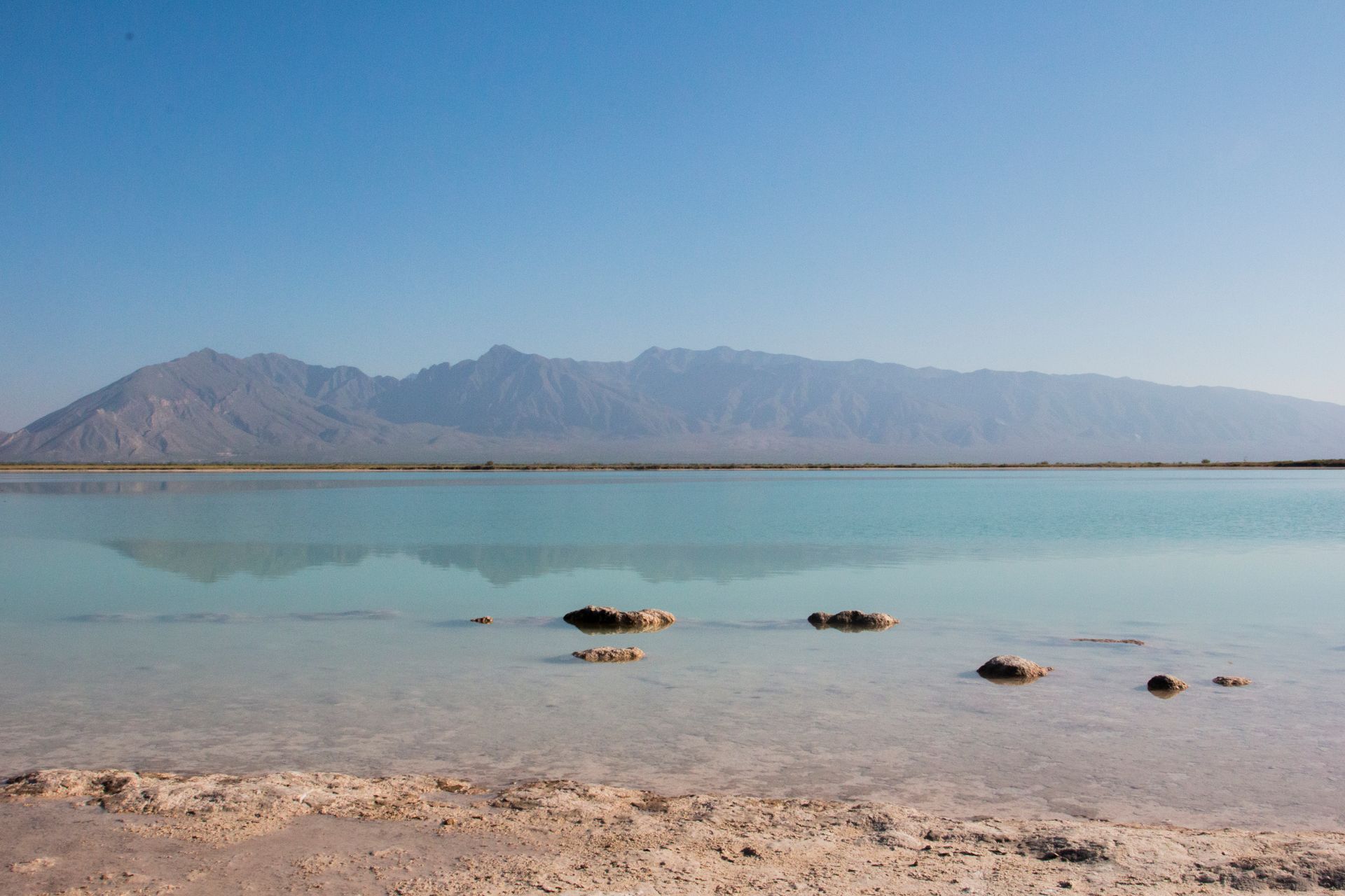 Un gran cuerpo de agua con montañas al fondo.