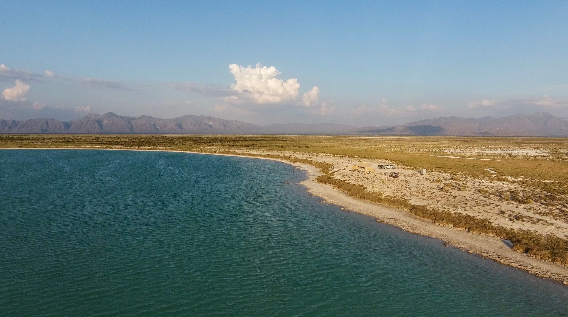 Una vista aérea de un lago con montañas al fondo.