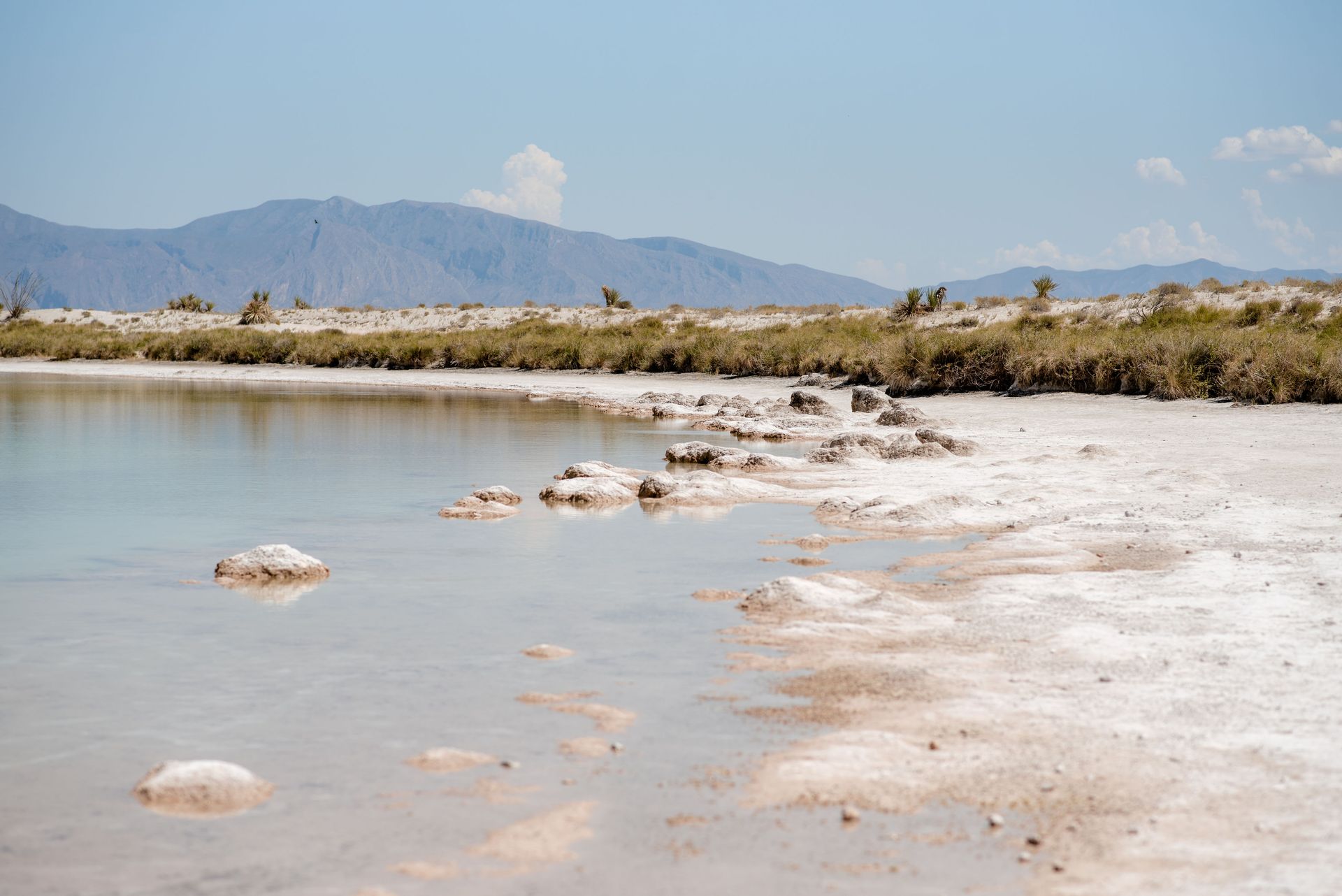 Un gran cuerpo de agua con montañas al fondo.