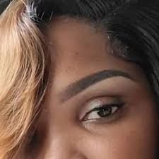 Close-up of a person's eye and eyebrow; skin is brown, eye is brown, and eyebrow is arched and filled.