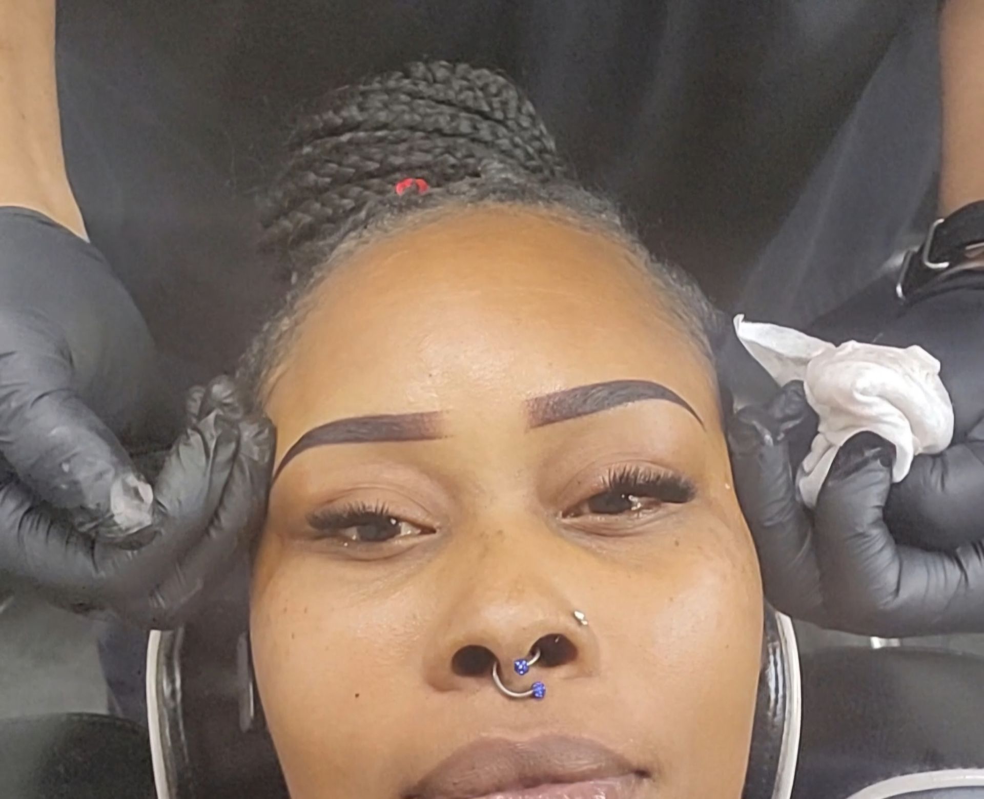 A woman is applying makeup to another woman 's face.