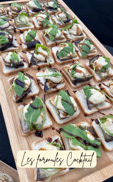 Plateau en bois de hors-d'œuvre : pain grillé garni d'aubergines, de sauce crémeuse, de roquette et de glaçage balsamique.