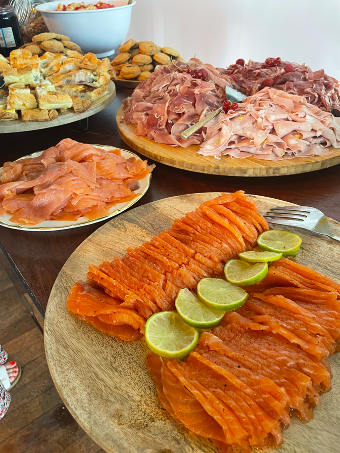 Buffet composé de saumon fumé, de viandes et de pâtisseries diverses.