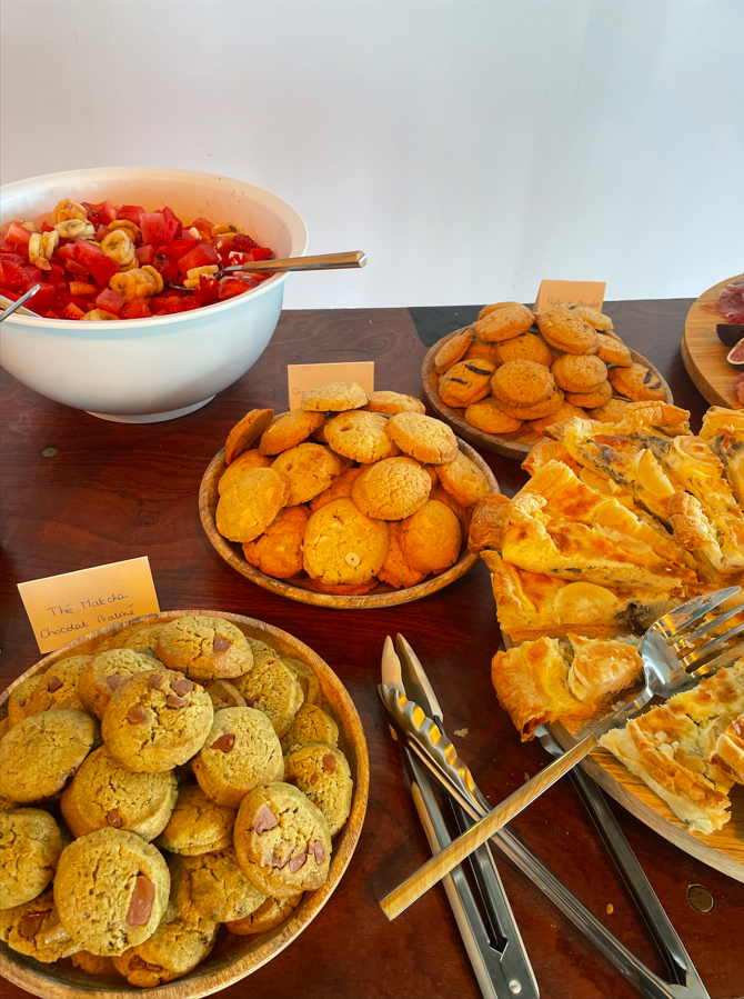 Buffet composé de biscuits, de quiche et d'un bol de tomates hachées et de noix.