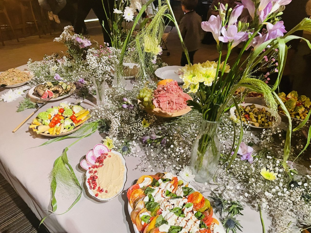 Table de buffet avec divers aliments et compositions florales.