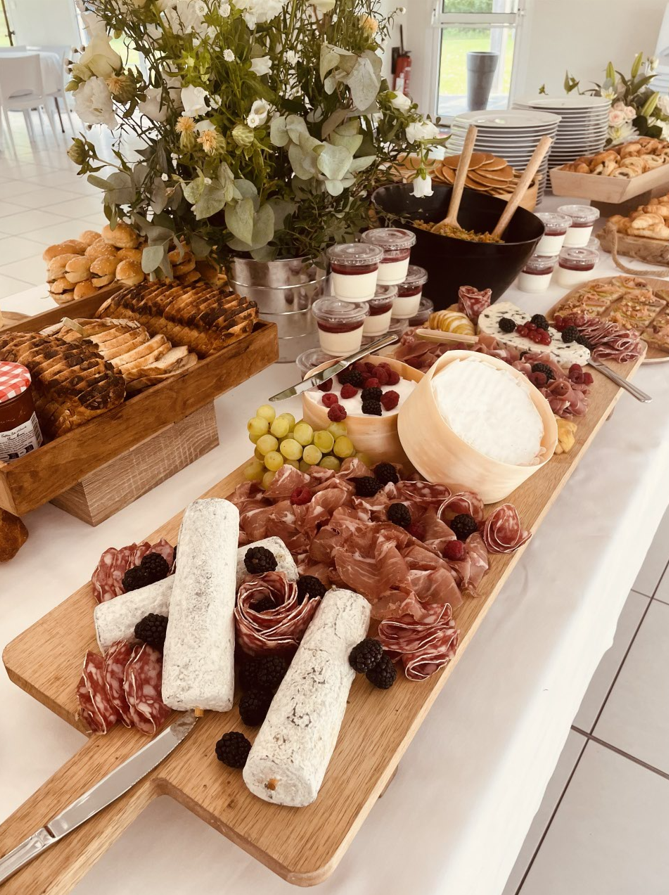 Un buffet chargé de charcuterie, de desserts et de fruits, y compris du fromage, des craquelins et des gâteaux.