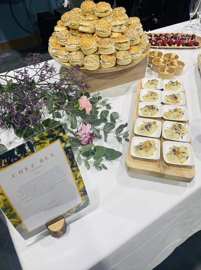 Buffet avec diverses entrées : biscuits, bouchées de pommes de terre, framboises. Une enseigne Chez Rex est visible.