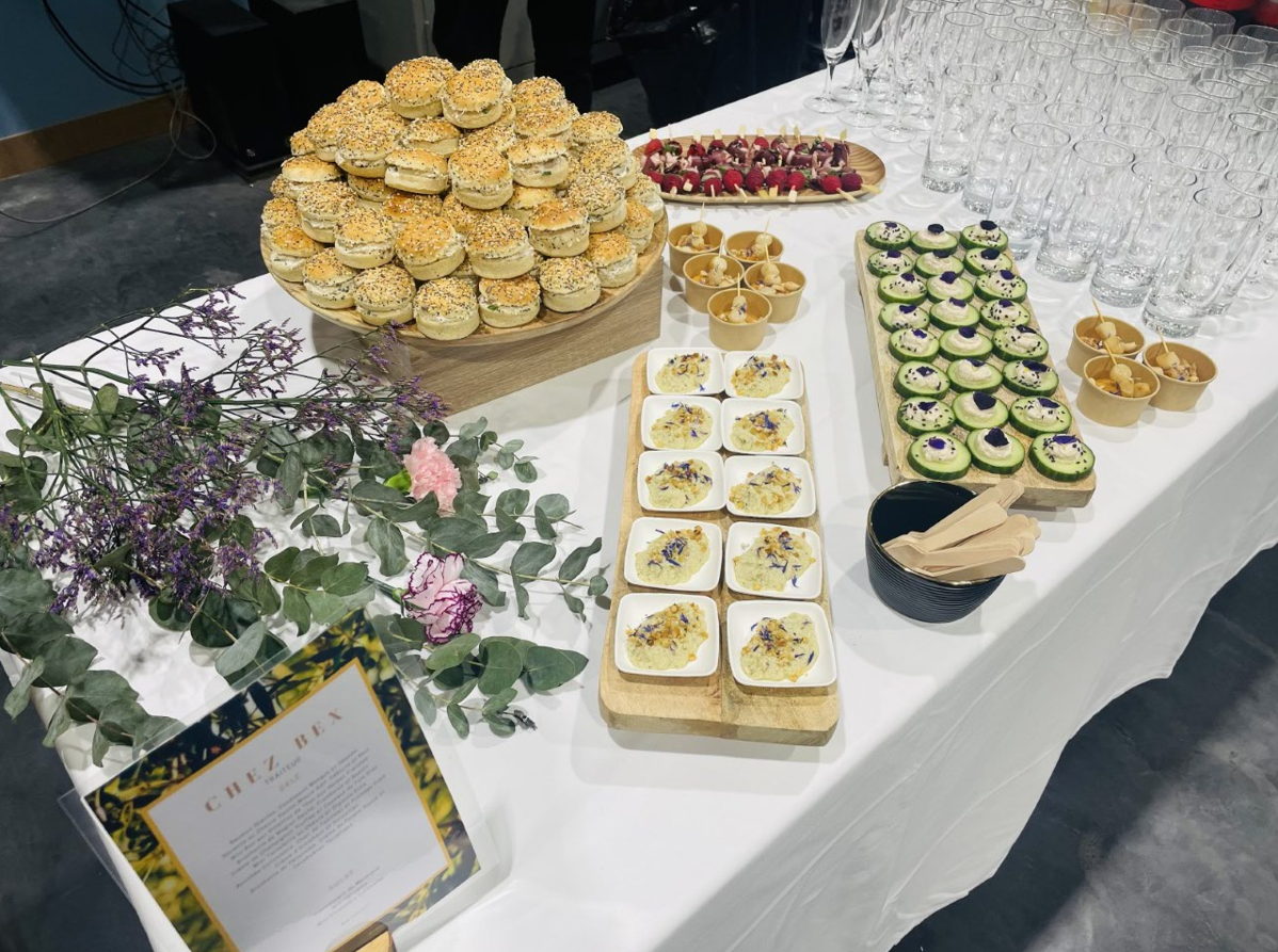 Buffet avec diverses entrées : mini quiches, œufs mimosa, bouchées de concombre et framboises.