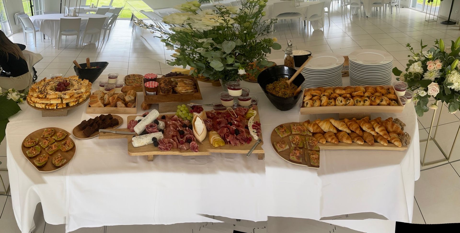 Table de buffet avec divers apéritifs, compositions florales et linge blanc par Chez Bex, traiteur au Havre