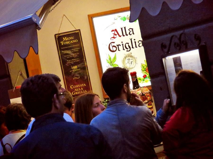 Persone che ordinano cibo in un ristorante, è visibile il cartello 