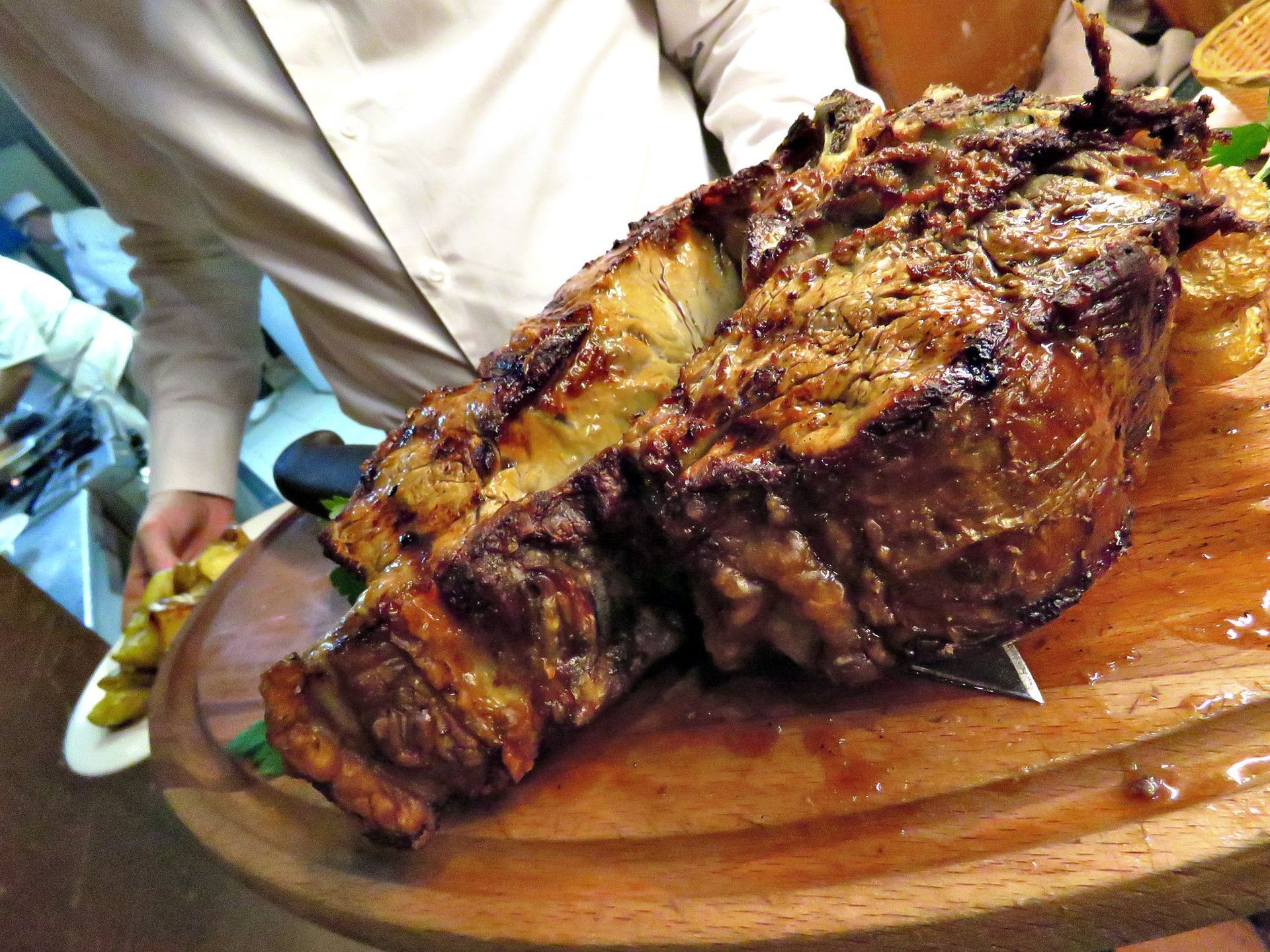 Le mani prendono biscotti e bicchieri di liquido ambrato su un piatto bianco.