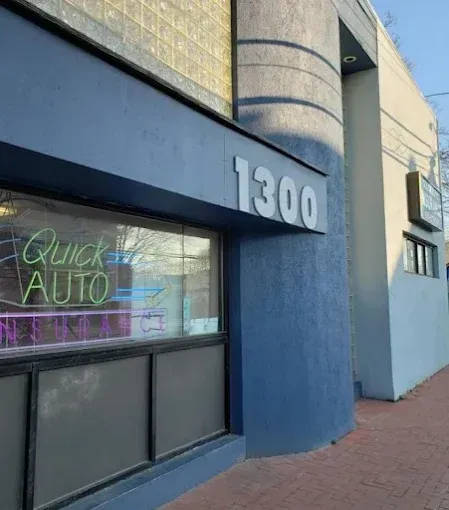 A blue building with a neon sign that says quick auto on it.