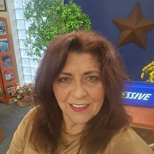 A woman is taking a selfie in front of a blue box that says massive.