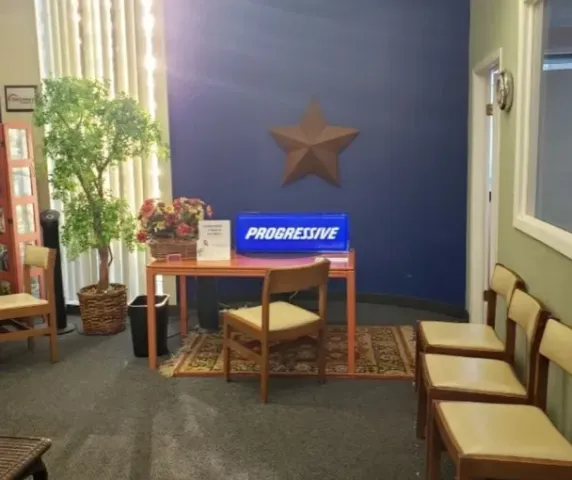 A progressive sign is on a table in a waiting room
